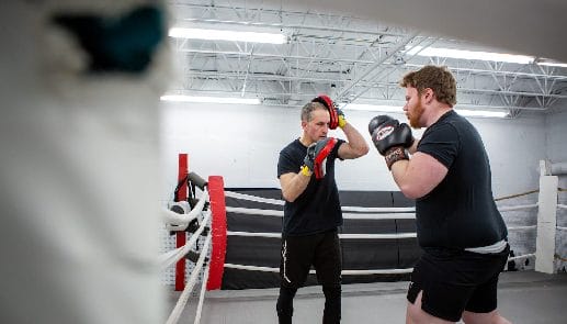 Two men sparring in a boxing gym